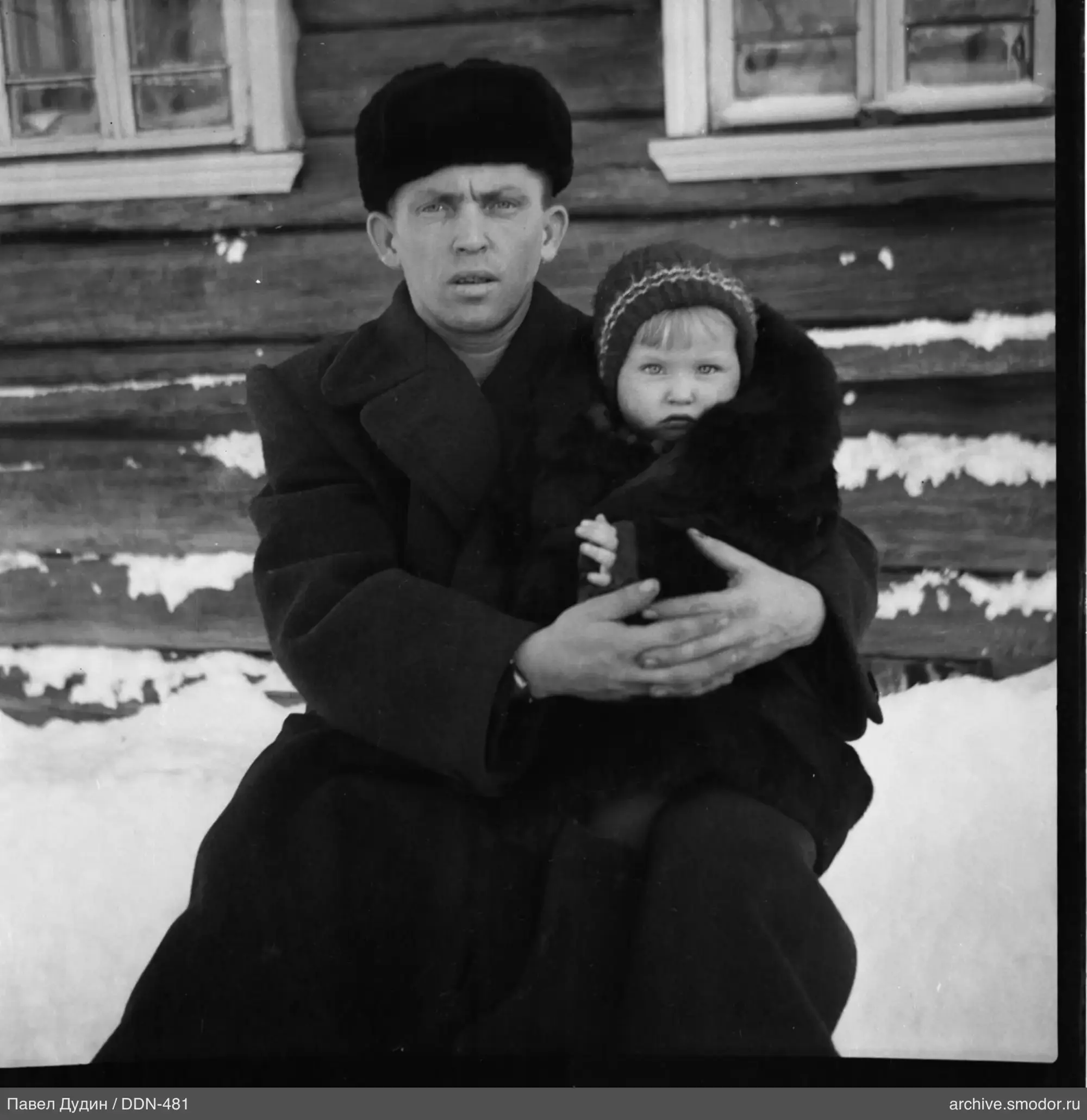 Мужчина с ребёнком у деревянной стены