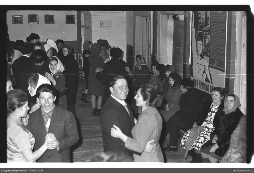Couples dancing in a room with posters