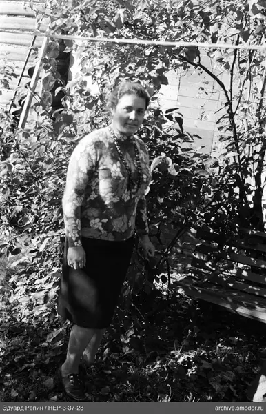 Frau zwischen Büschen und Laub