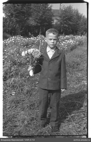Ganzkörperporträt eines Jungen mit Blumen und Kerze