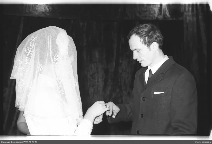 Man putting a ring on woman's finger