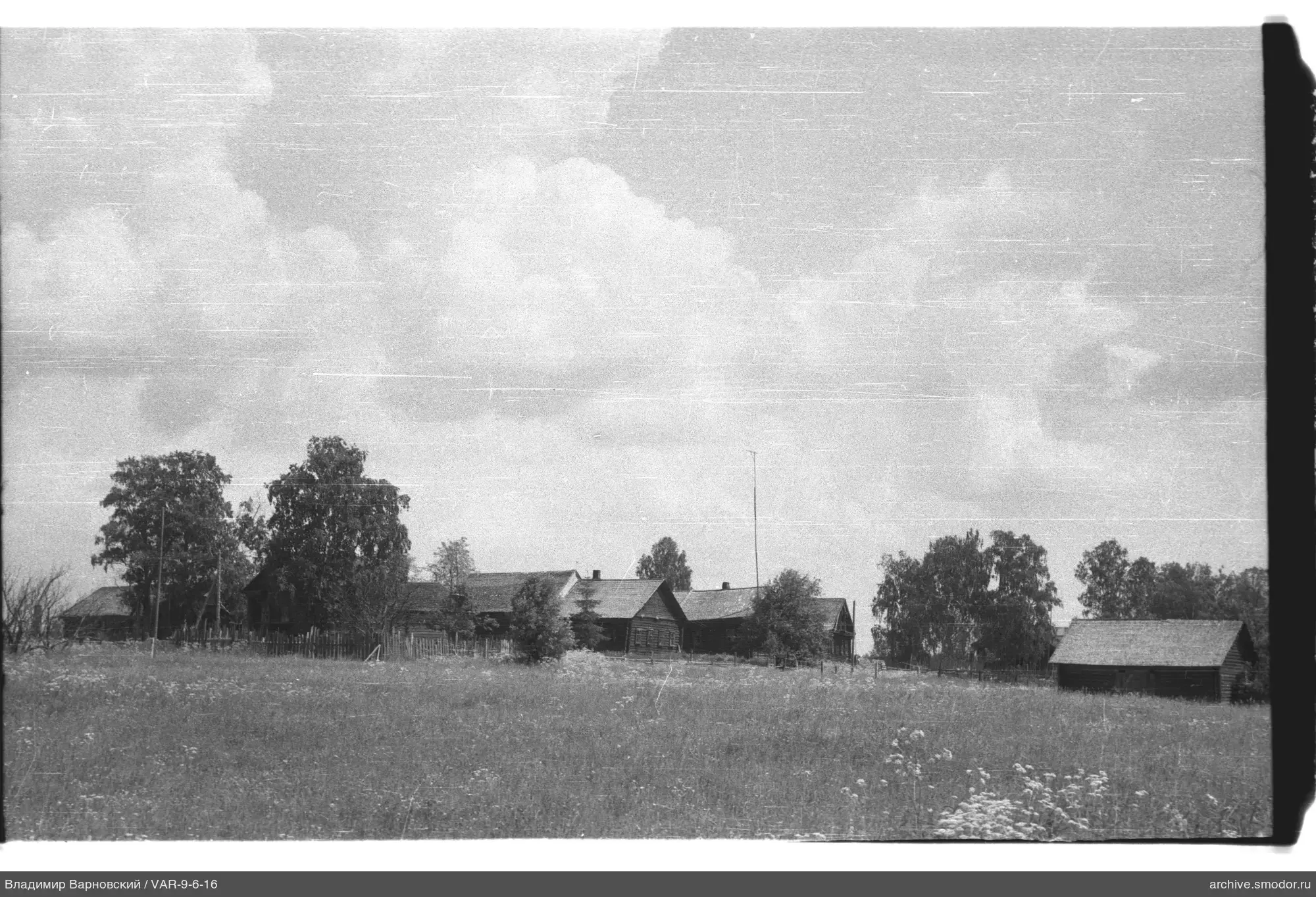 Landschaft mit Holzhäusern und Schuppen