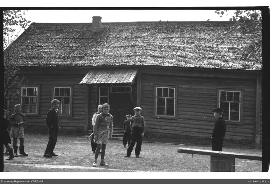 Группа детей на улице у деревянного здания