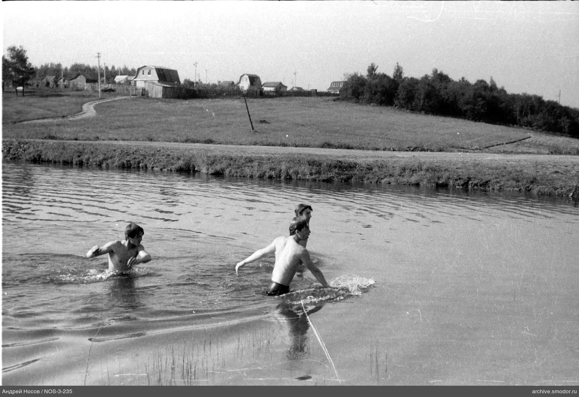 Молодые мужчины в воде у берега