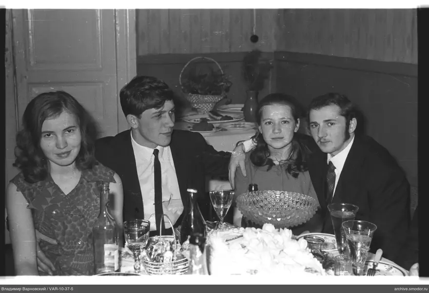Group sitting at a table with dishes and fruits