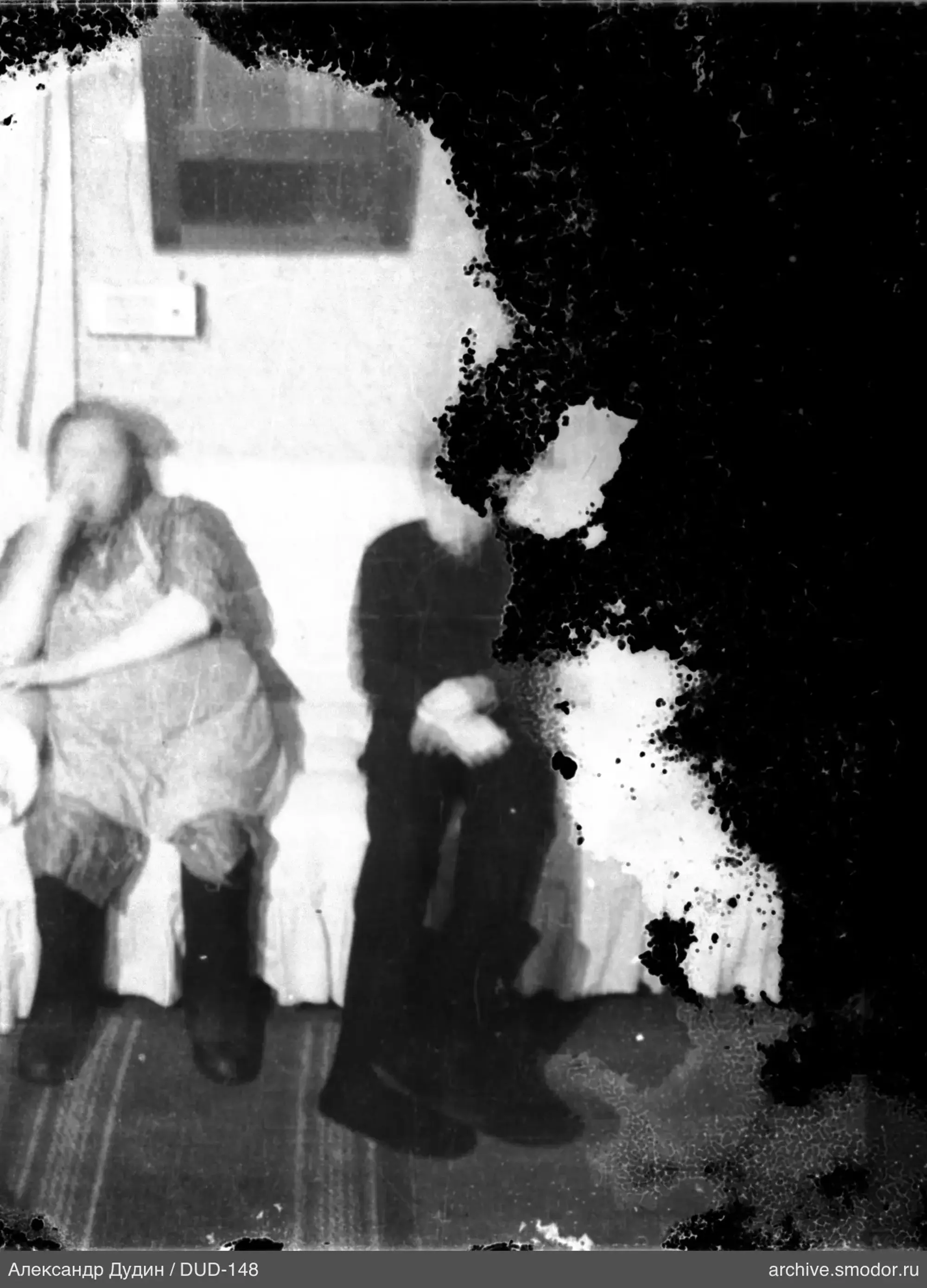 Два мужчины сидят у светлой стены