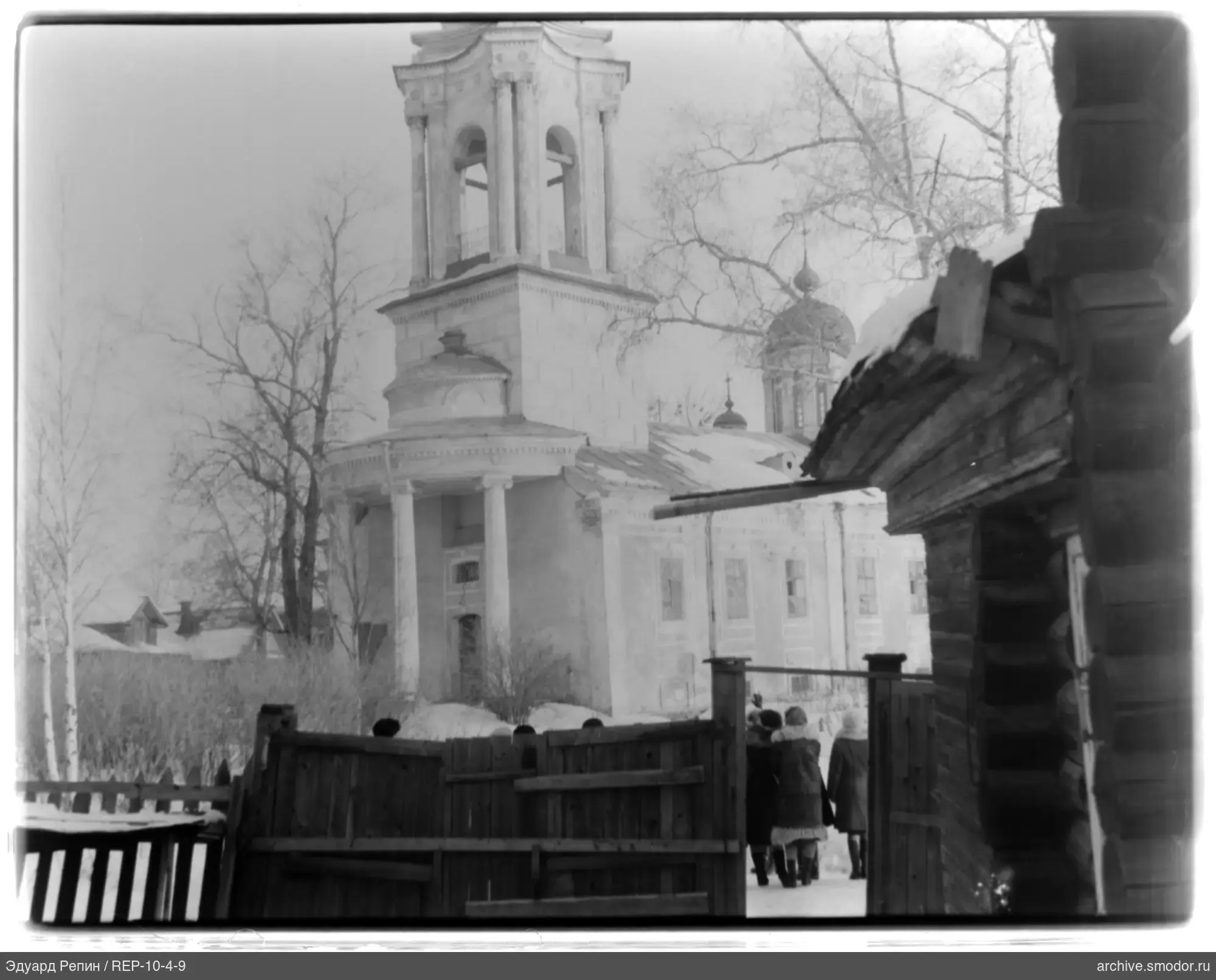 Winter street scene with wooden fence and stone building