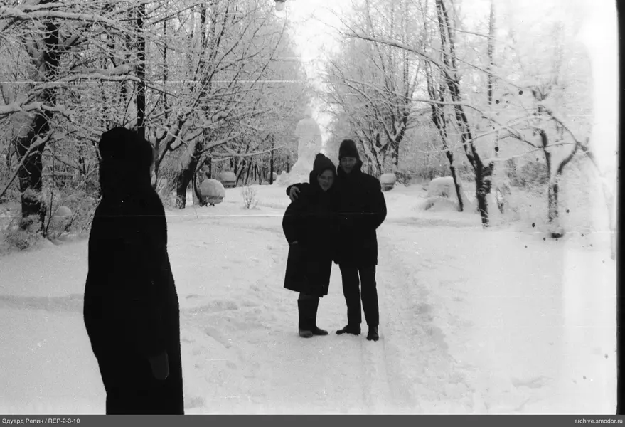 Drei Personen auf einer verschneiten Allee