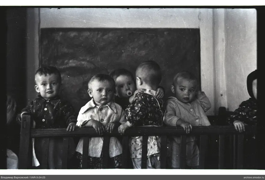 Gruppenporträt von Kindern hinter einem Zaun