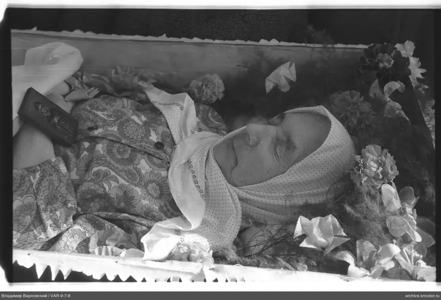 Женщина в гробу с иконой и цветами