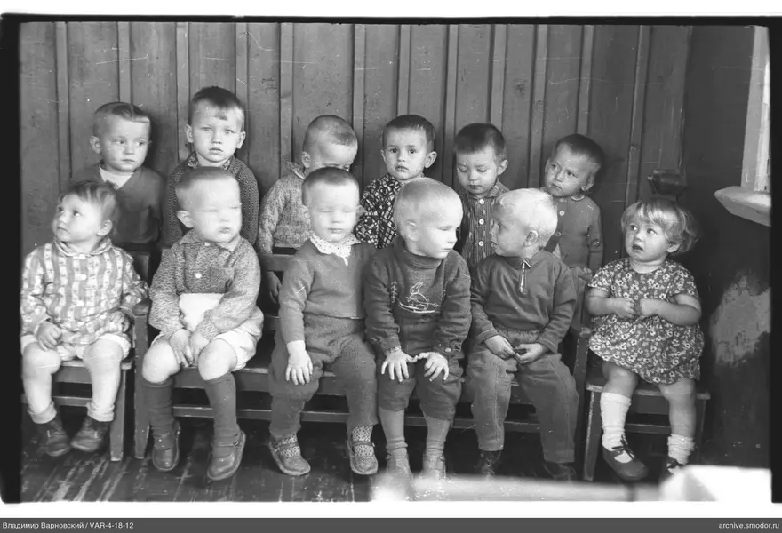 Gruppenporträt von Kindern an Holzwand