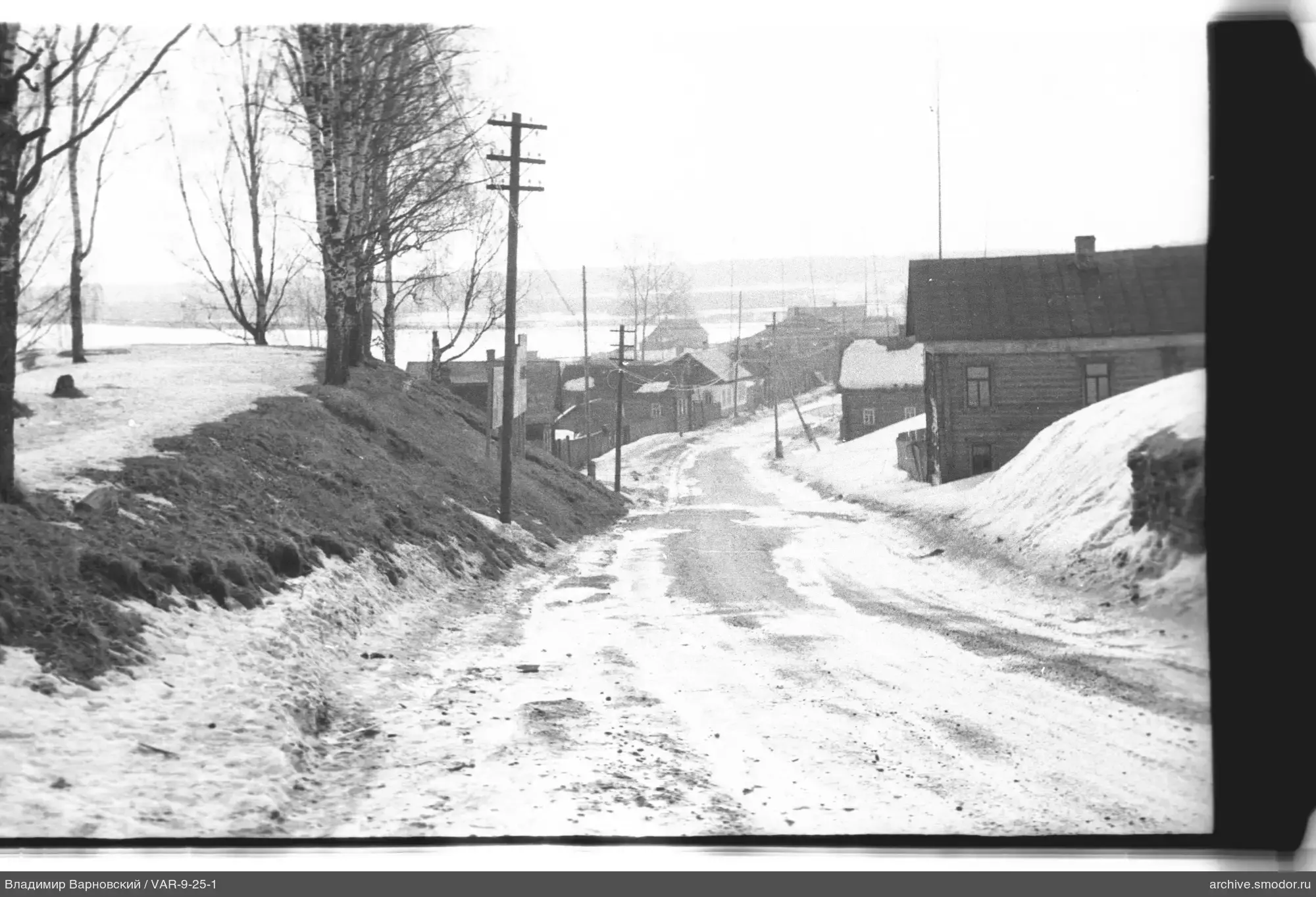 Holzhäuser und schneebedeckte Straße