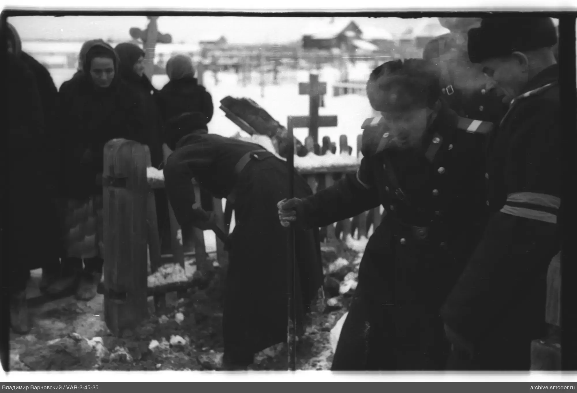 Menschen auf einem Friedhof, Frau gräbt Erde