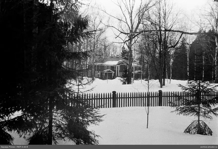 Holzzaun und Haus im Schnee