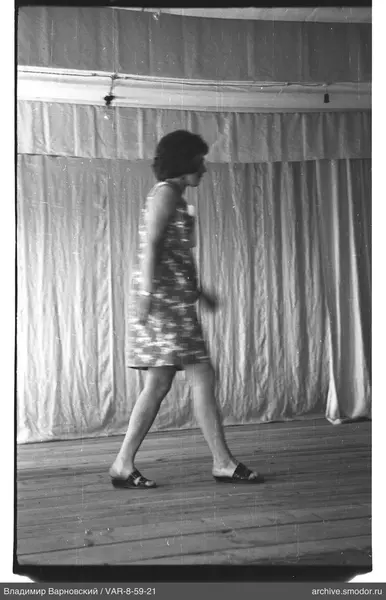 Frau im Blumenmusterkleid auf Holzboden