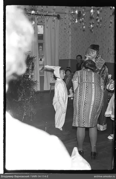 Child in rabbit costume by Christmas tree