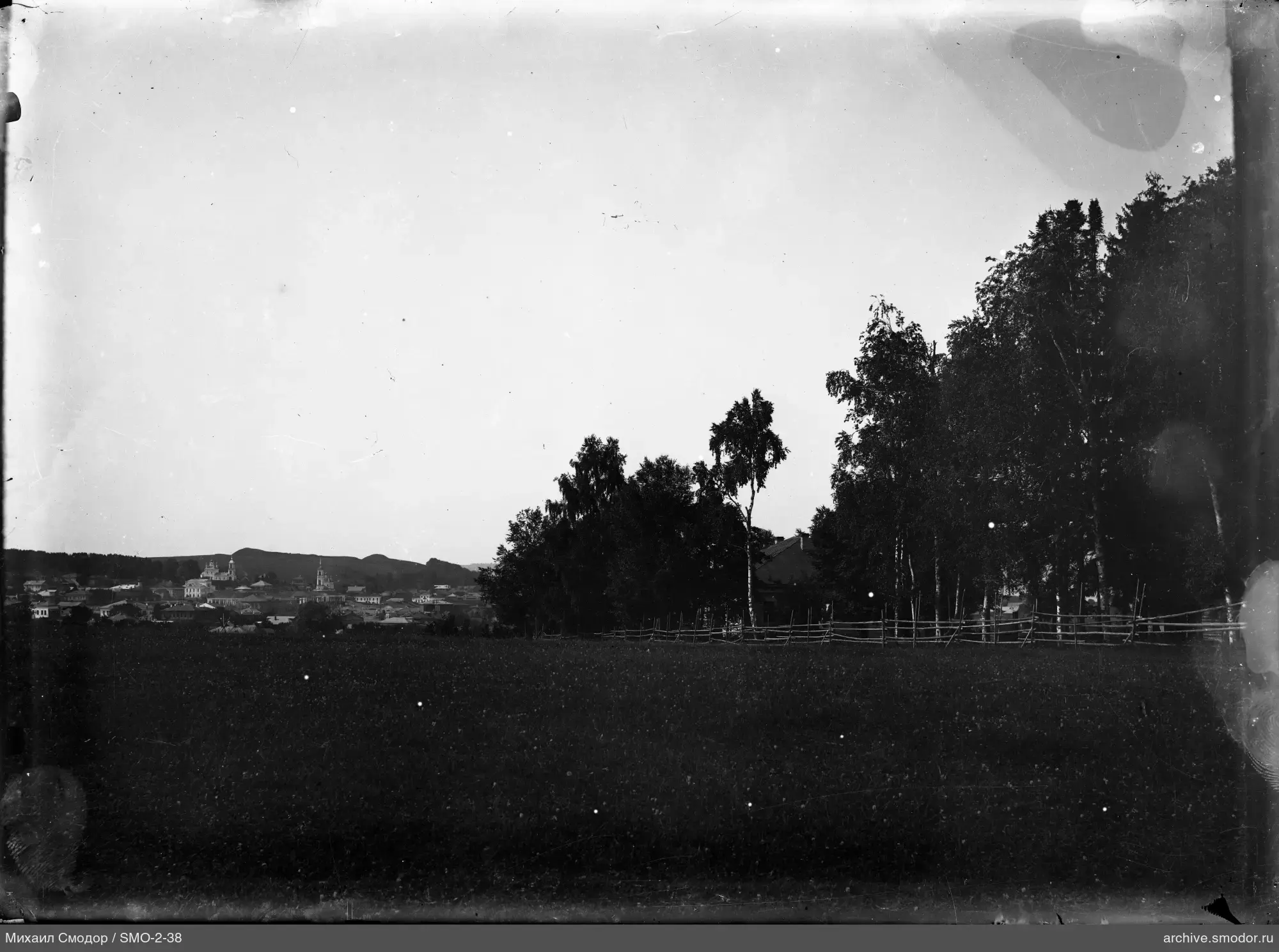 Landschaft mit Feld, Bäumen und Kirchen