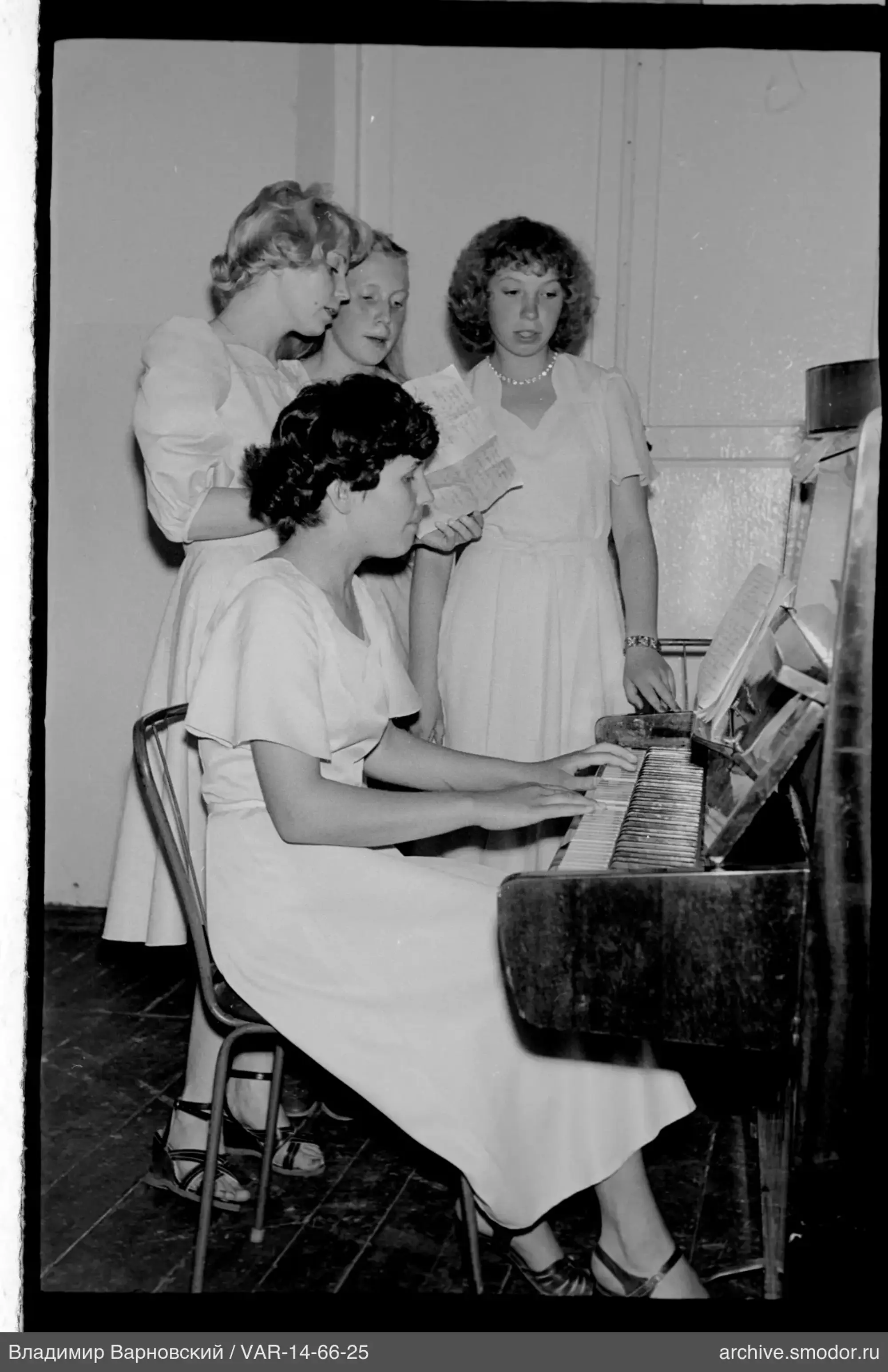 Gruppe von Mädchen mit Klavier und Notenblättern