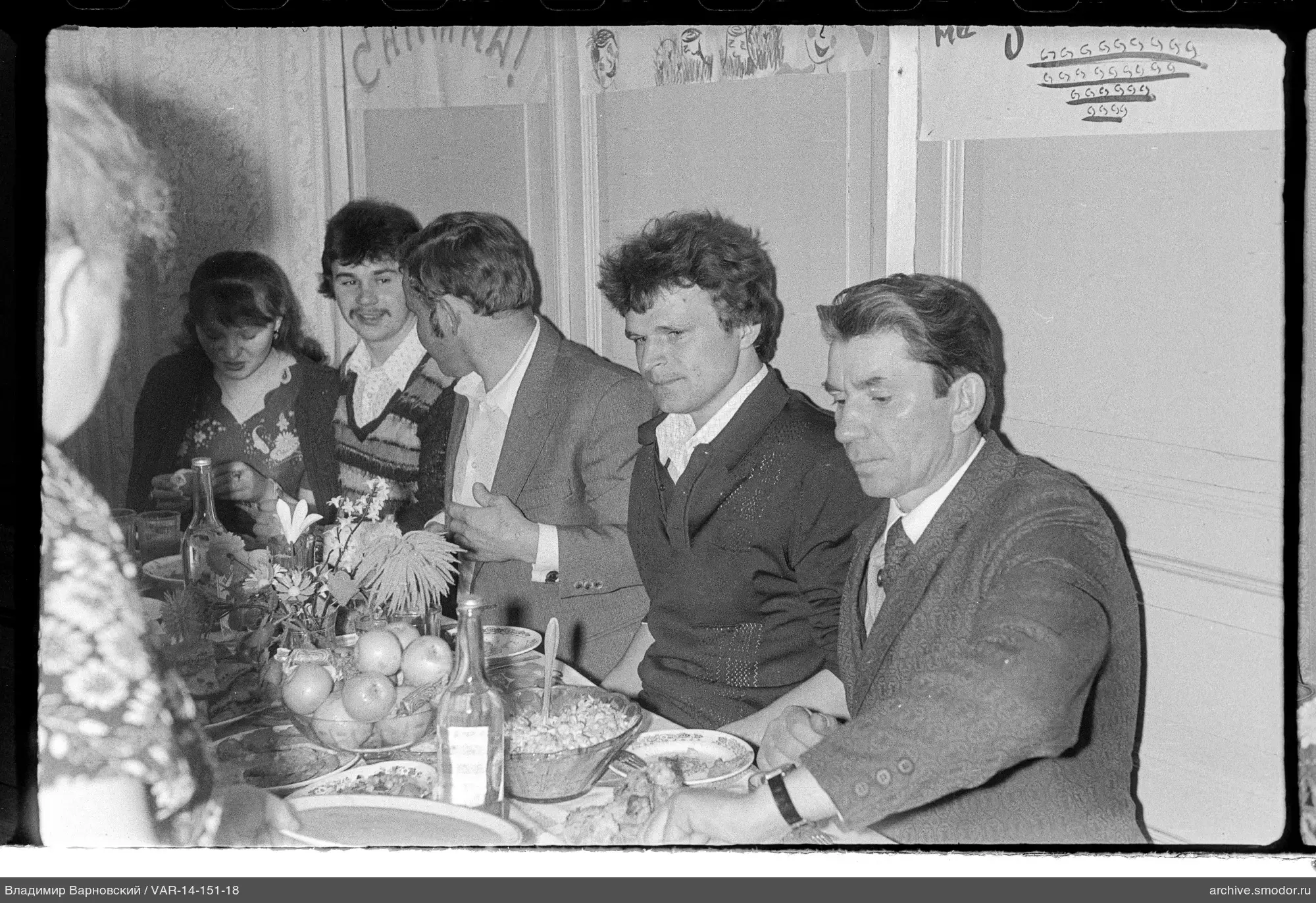 Menschen an einem Tisch mit Speisen und Blumen