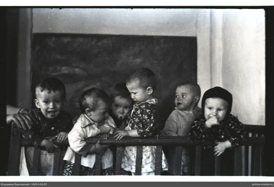 Gruppenporträt von Kindern hinter einem Zaun