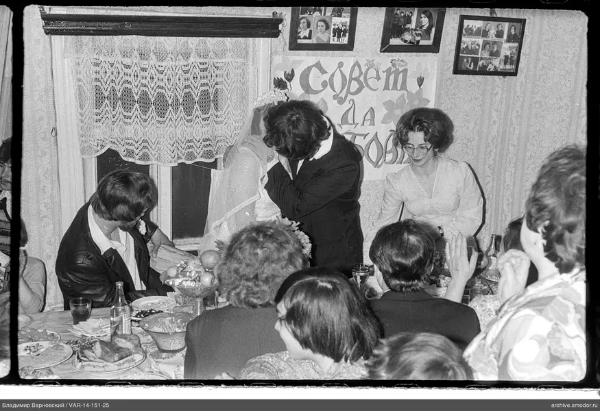 Mann küsst Frau im Hochzeitskleid
