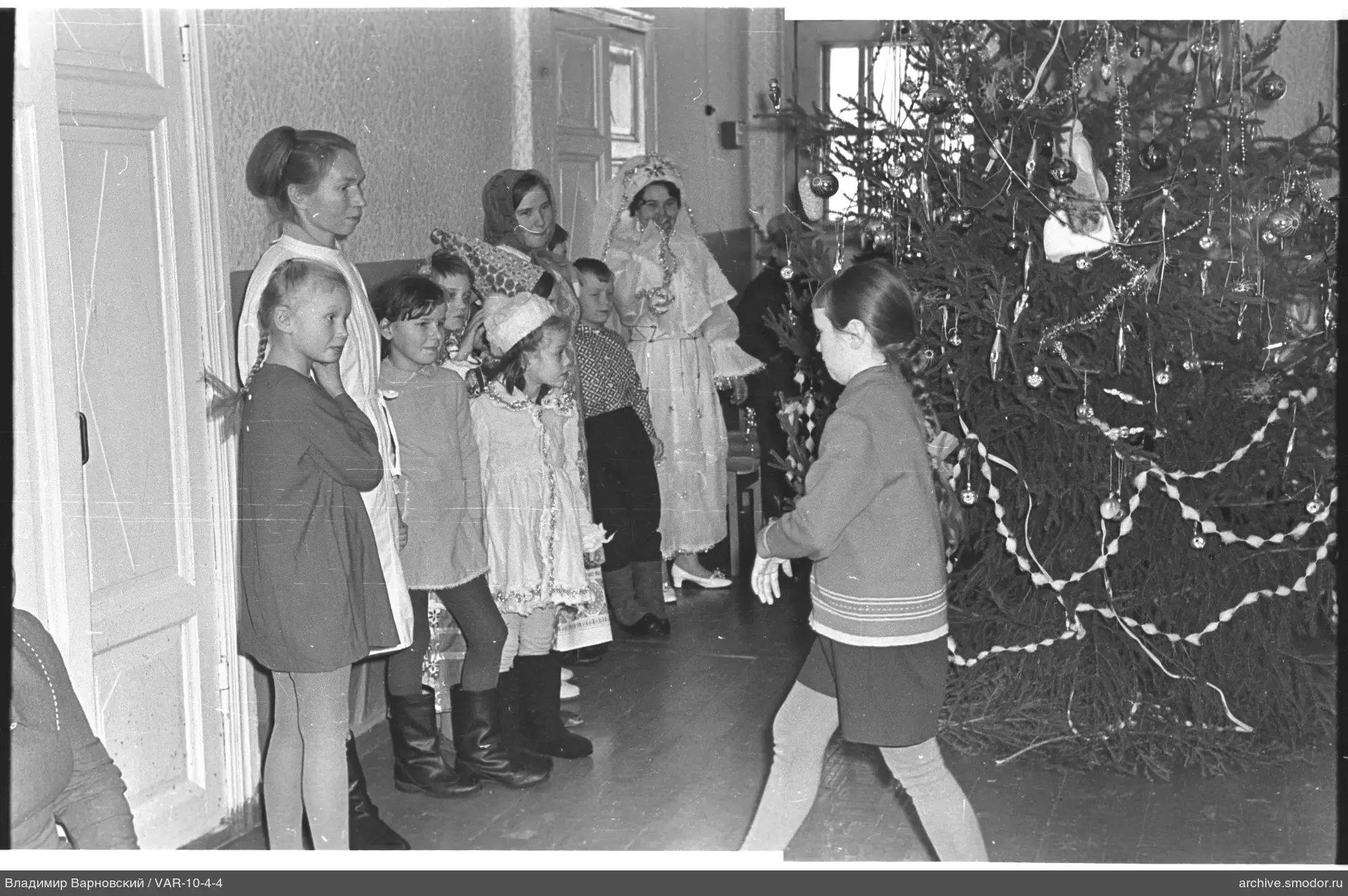 Children and women near decorated Christmas tree