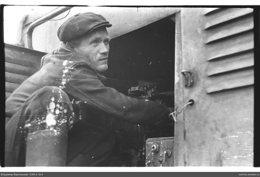 Man in open compartment touching mechanism