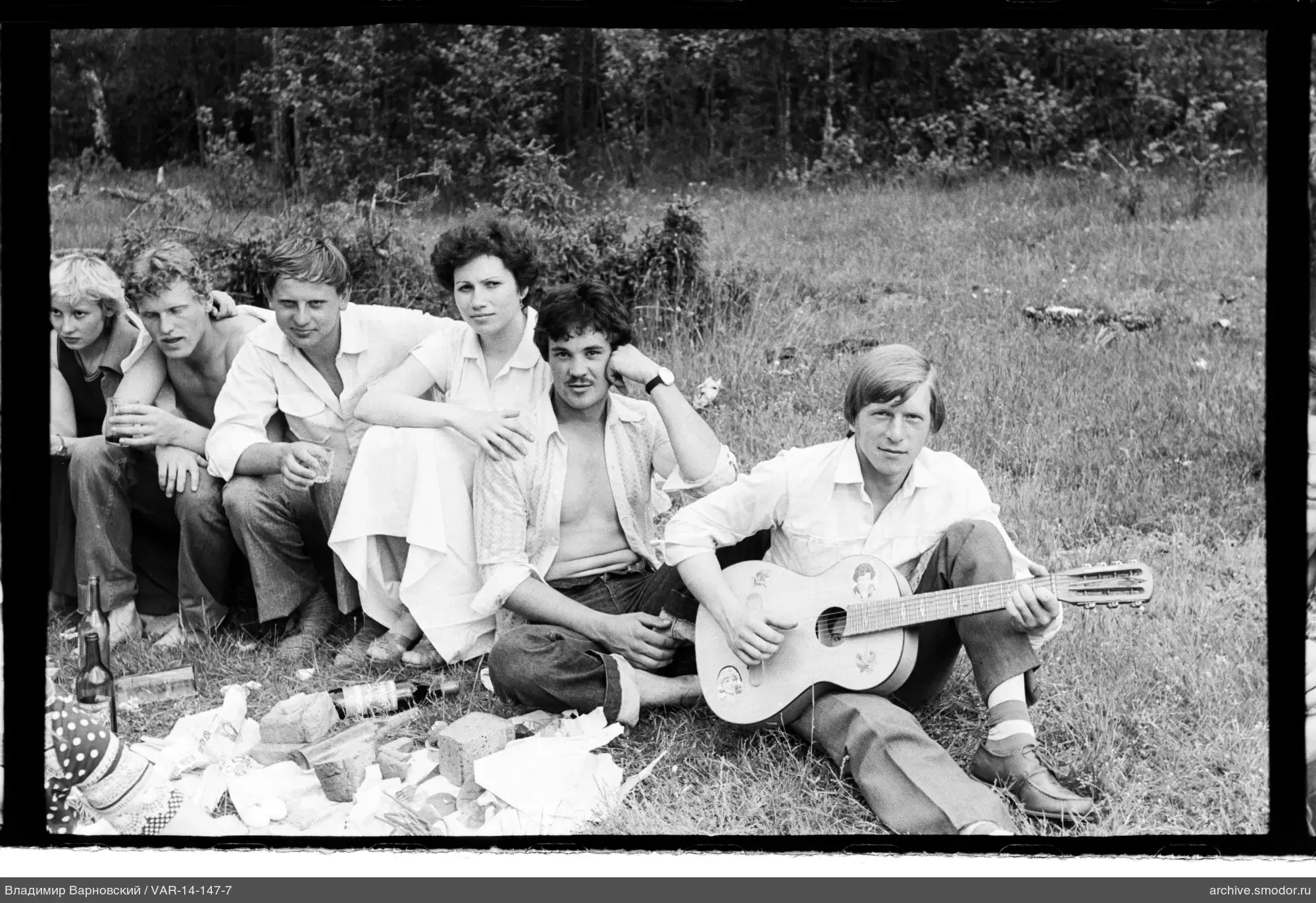 Gruppe auf Gras mit Gitarre und Essen