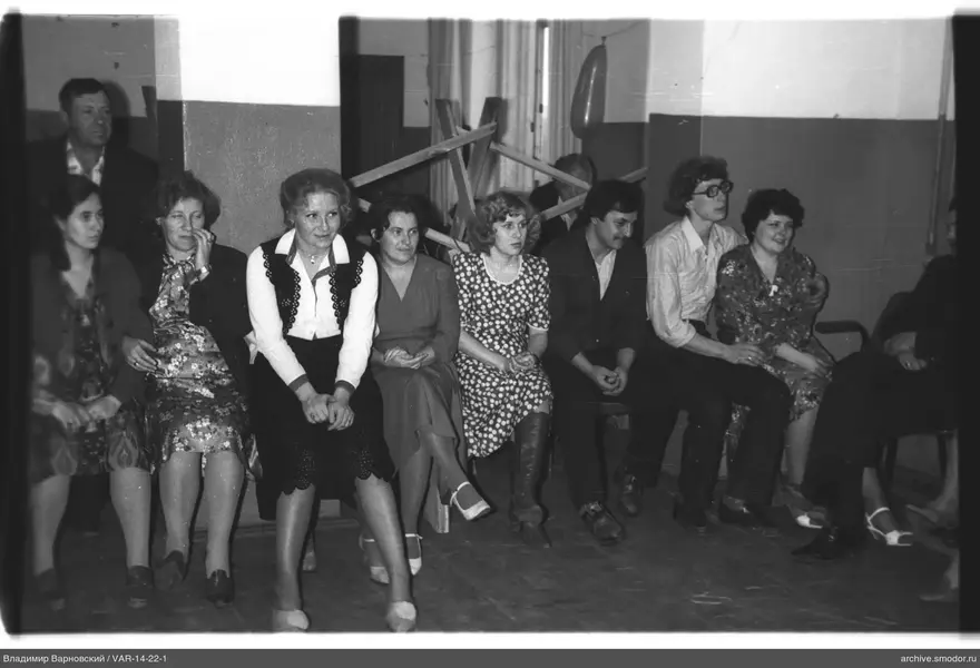 Gruppe von Menschen auf einer Bank an der Wand