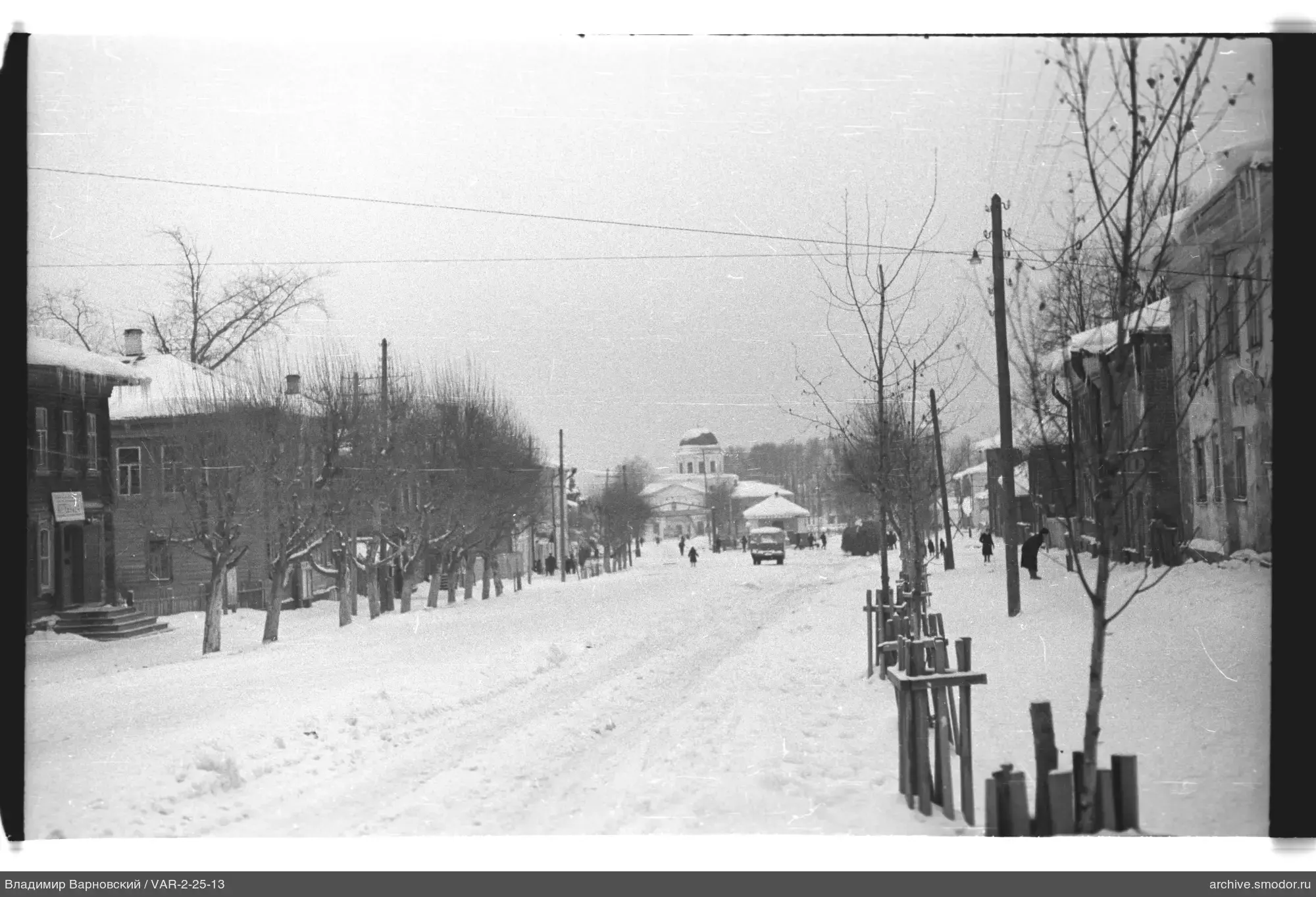 Snow-covered street with trees and buildings
