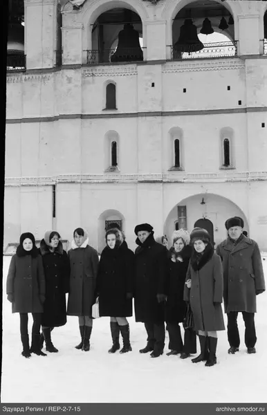 Gruppe von Menschen vor einem Gebäude mit Bögen