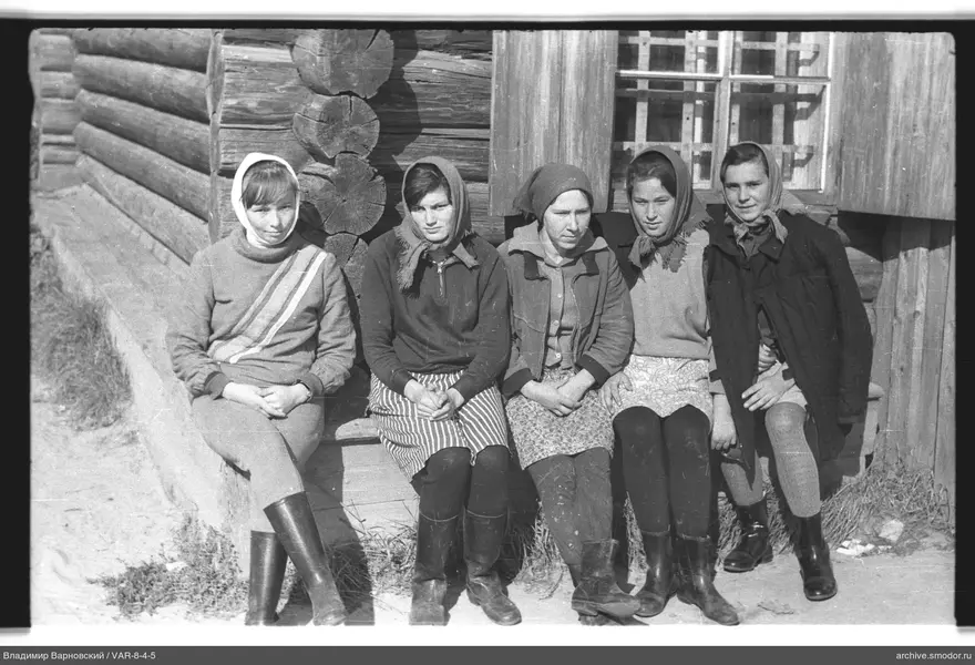 Gruppenporträt von Frauen am Holzhaus