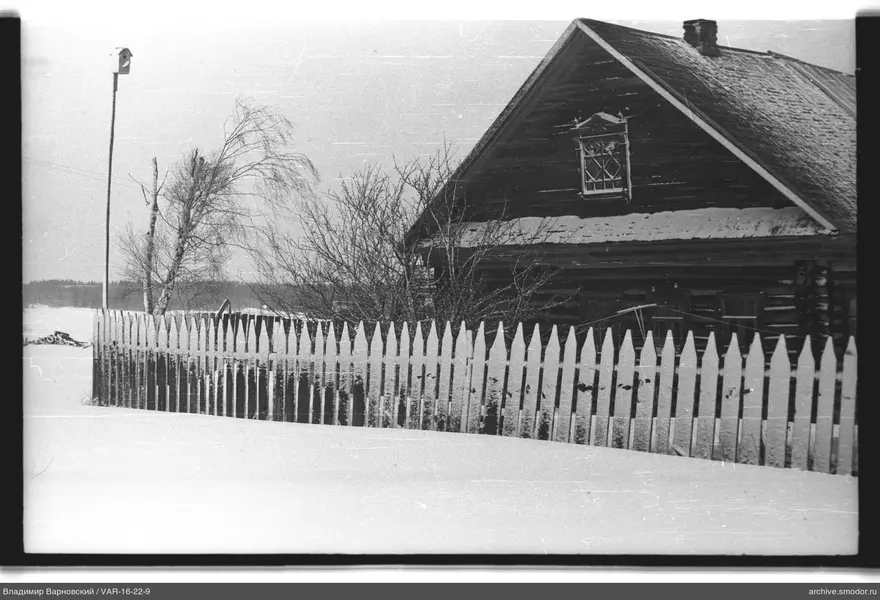 Holzhaus mit Zaun und Schnee