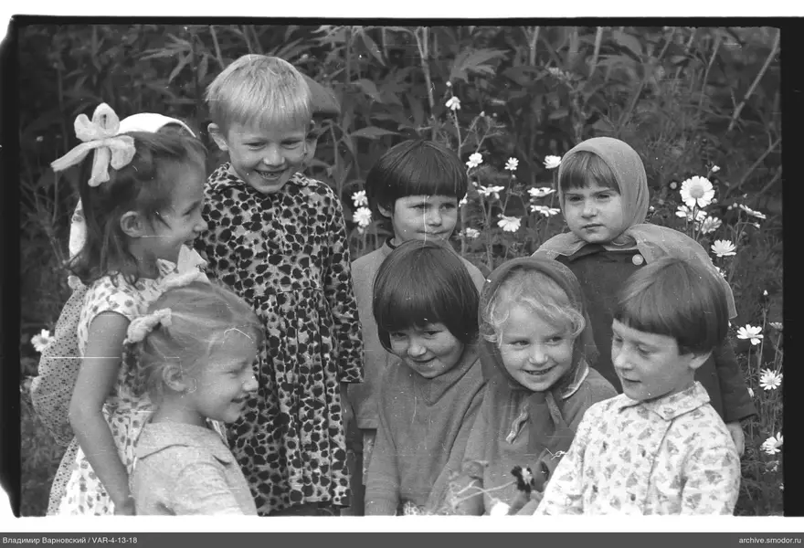 Gruppenporträt von Kindern vor blühenden Pflanzen
