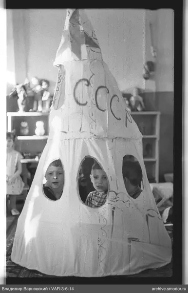 Kinder in einem Stoffmodell einer Rakete mit Aufschrift СССР