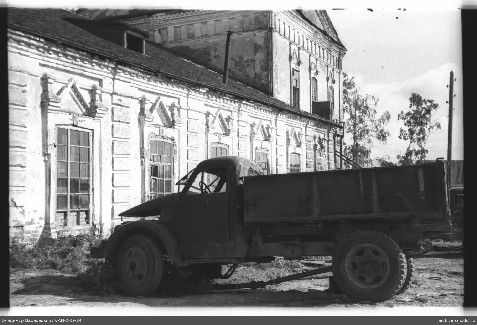 Грузовой автомобиль у кирпичного здания