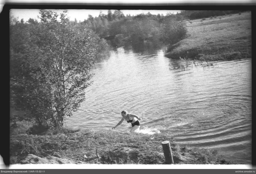 Женщина выходит из воды на берегу