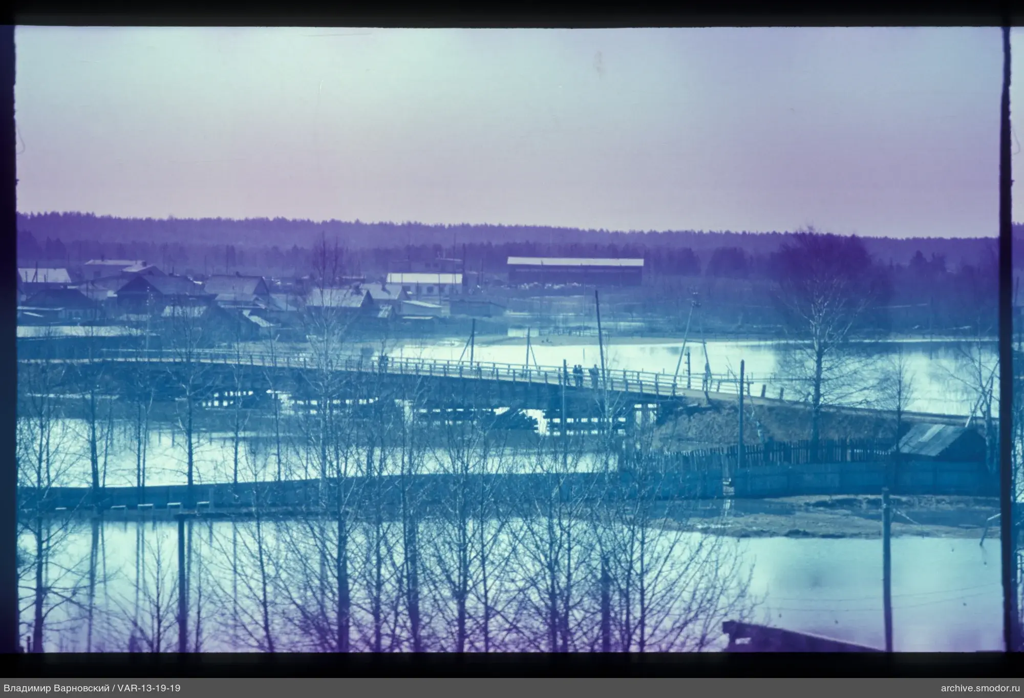 Wooden bridge with people and houses