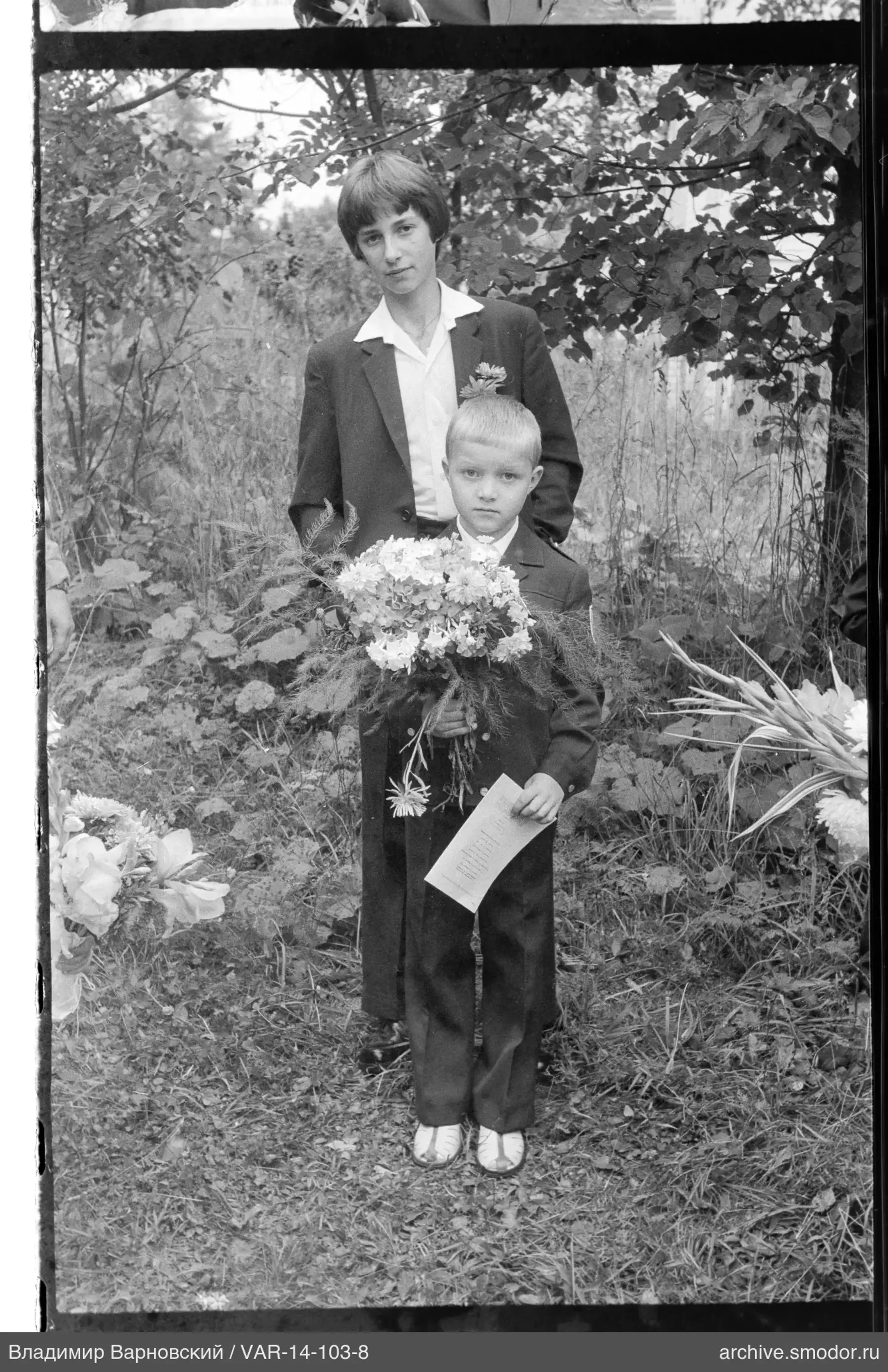 Zwei Jungen mit Blumenstrauß und Blume
