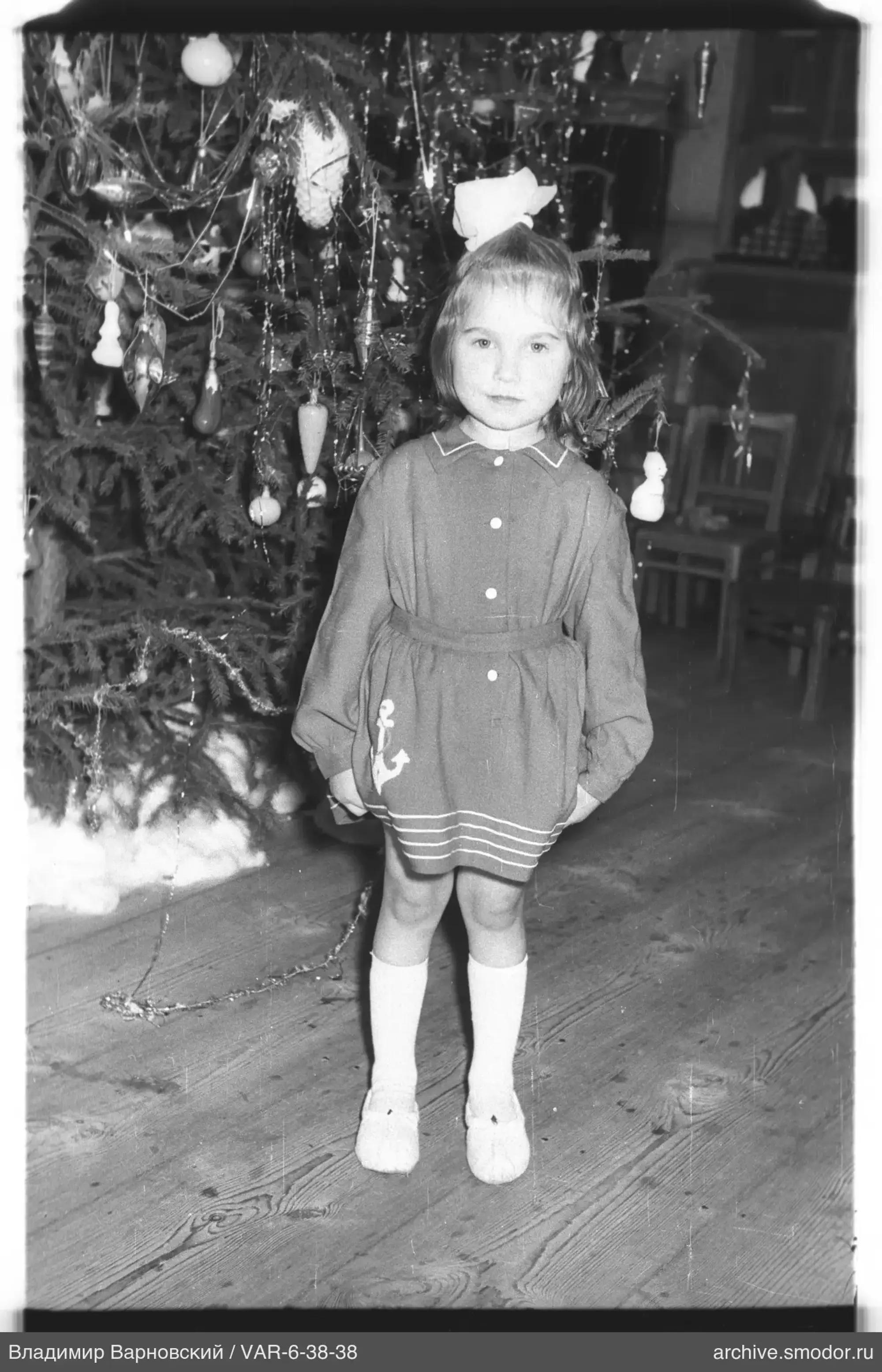Mädchen vor geschmücktem Weihnachtsbaum