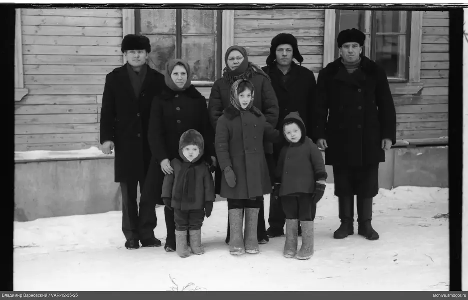 Группа взрослых и детей у деревянного дома