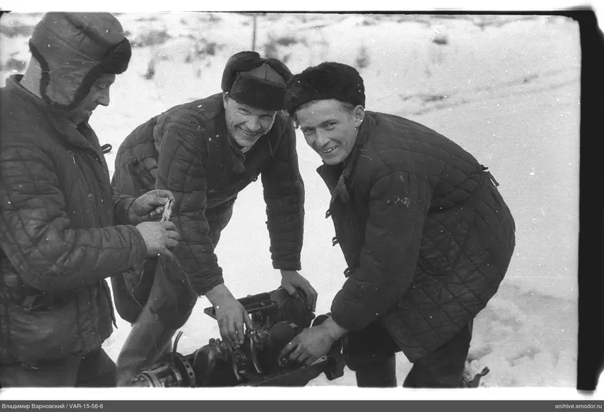 Drei Männer mit Mechanismus im Schnee