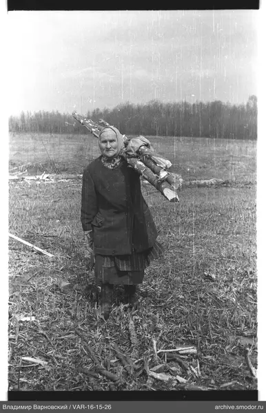 Frau mit Ästen auf dem Feld