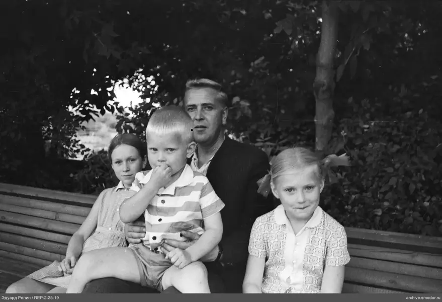 Mann mit Kindern auf einer Bank
