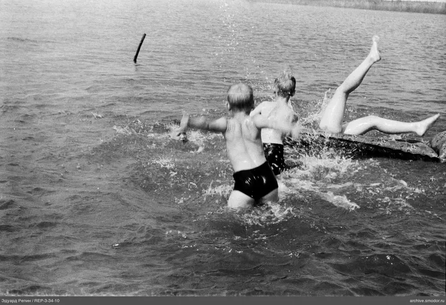 Kinder und Erwachsener im Wasser auf aufblasbarer Matratze