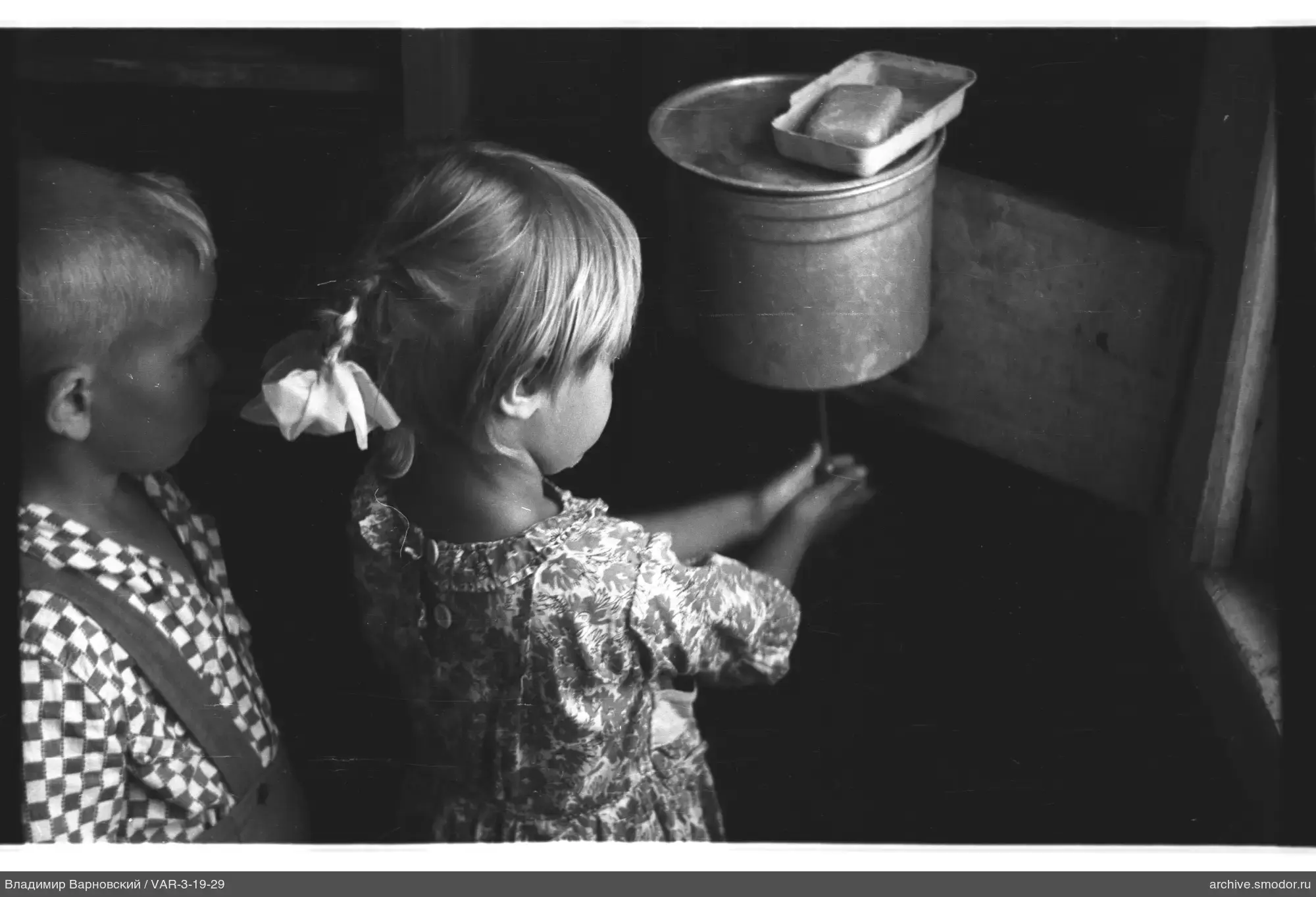 Children with soap by wooden wall