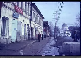 Улица с прохожими и кирпичным зданием