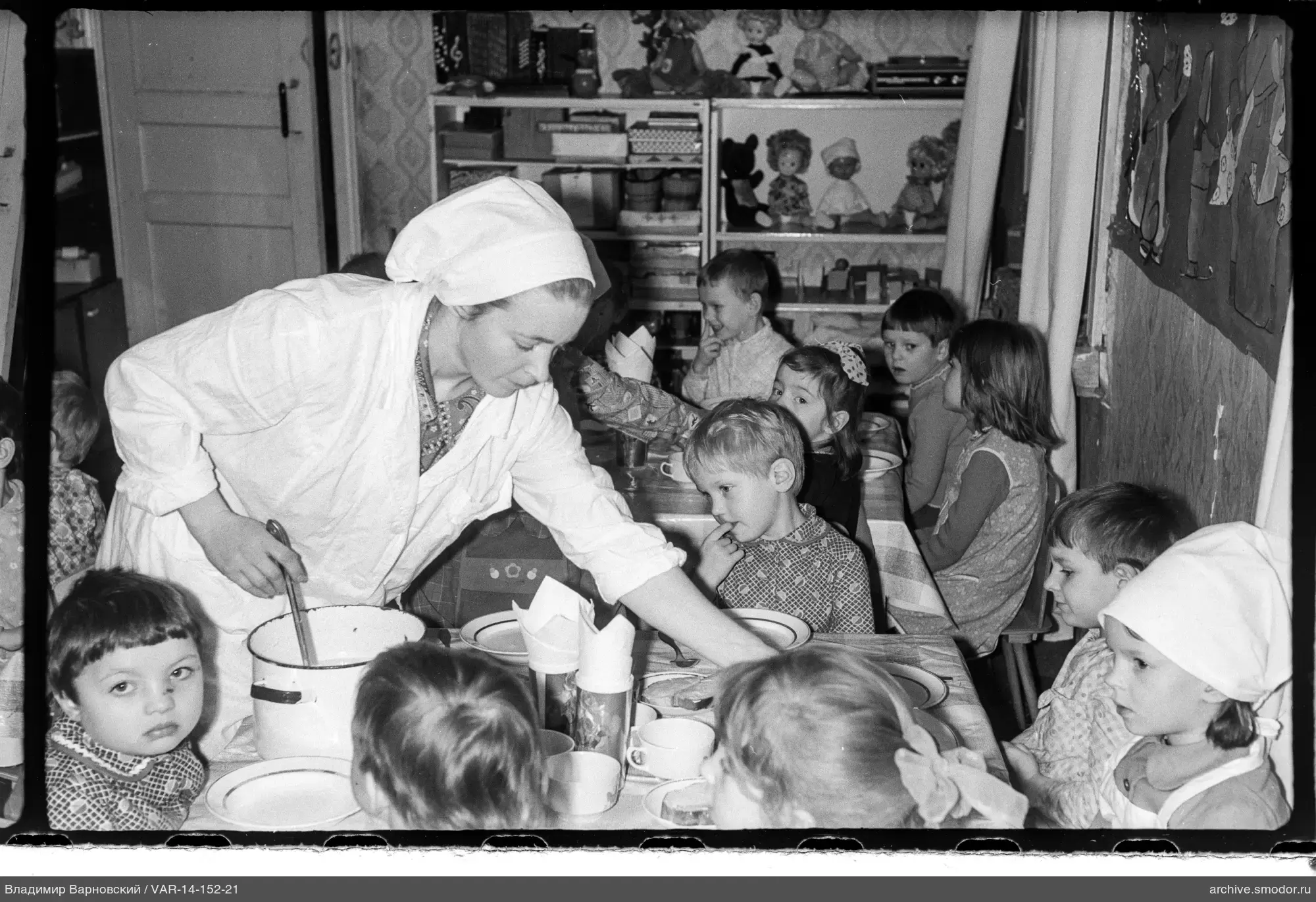 Frau verteilt Essen an Kinder