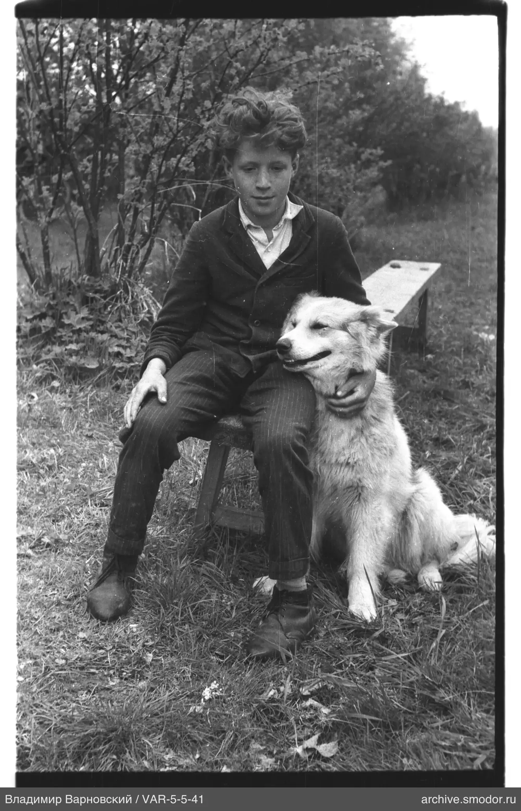 Junge mit Hund im Gras