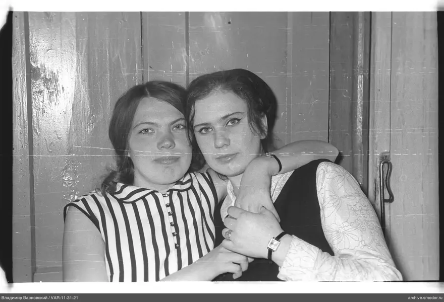 Portrait of two women against a wooden wall